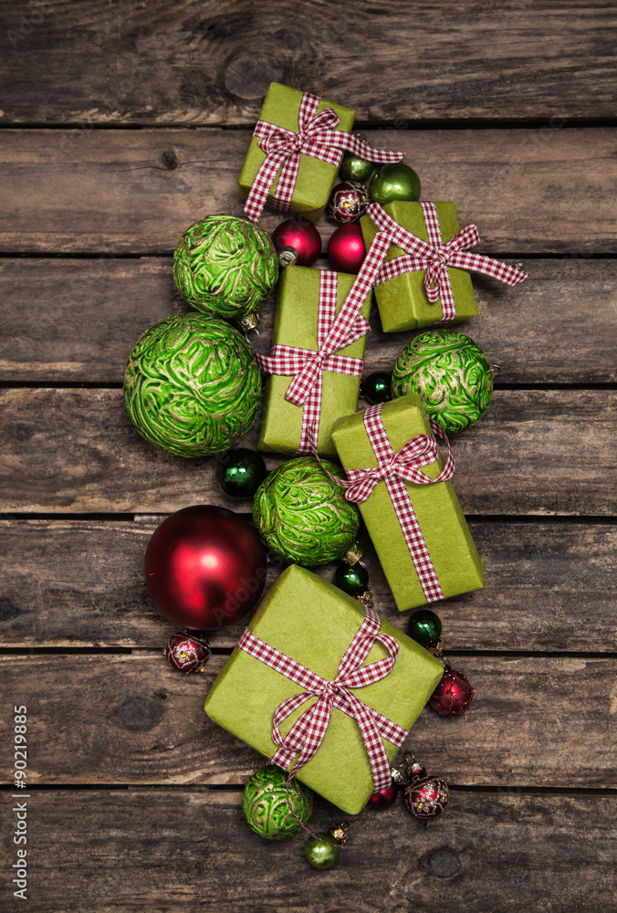 Geschenke weihnachtlich in grün und rot weiß kariert verpackt auf Holz Hintergrund zur Werbung an Weihnachten.