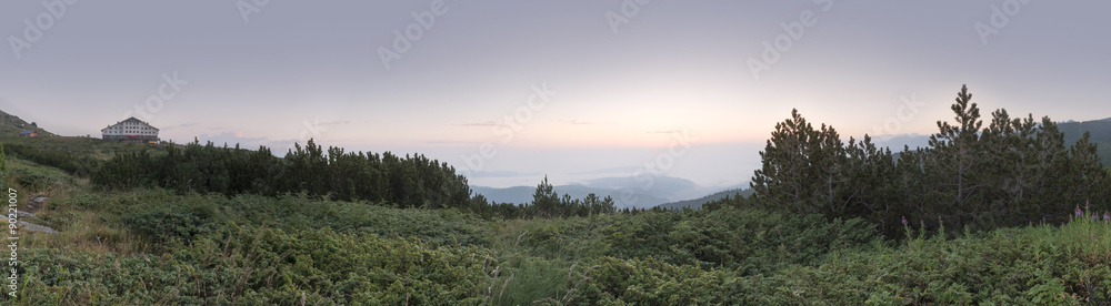 Sunrise in the mountain and hut. Panoramic image