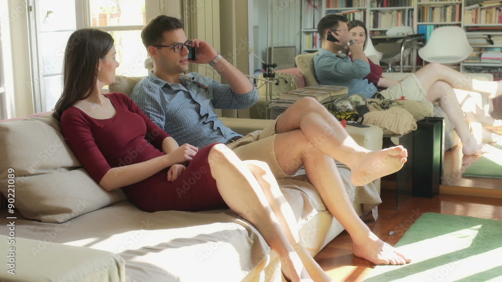 Couple relaxing on the sofa and chatting on cellphone
Couple relaxing on the sofa and chatting on cellphone
