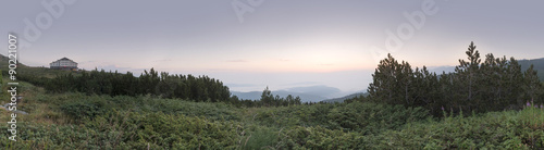 Sunrise in the mountain and hut. Panoramic image