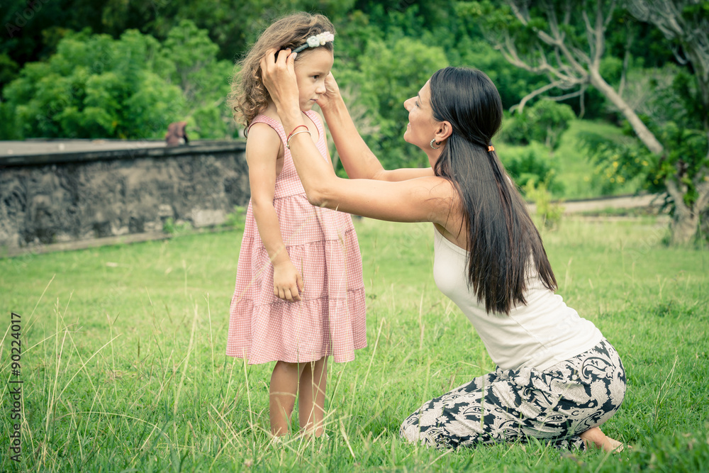 Naklejka premium Mother and daughter playing on the grass at the day time.