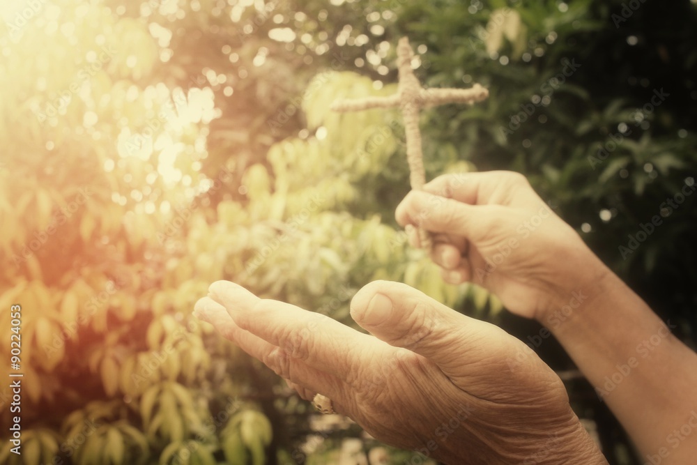 Fototapeta premium Hands praying with cross