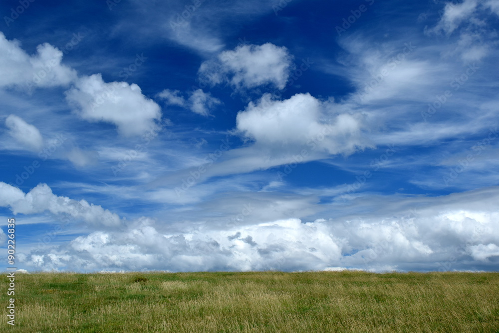 Highlands of grass and clouds in the sky