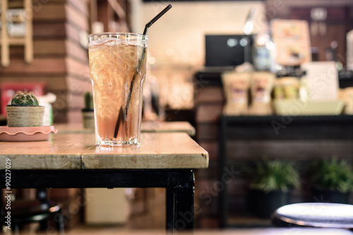 Glass of ice tea on wooden table in coffee shop