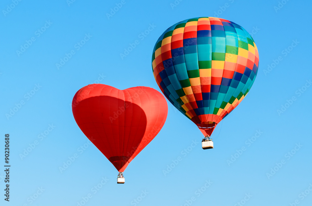 Fototapeta premium Two colored hot air balloon flying in the blue sky