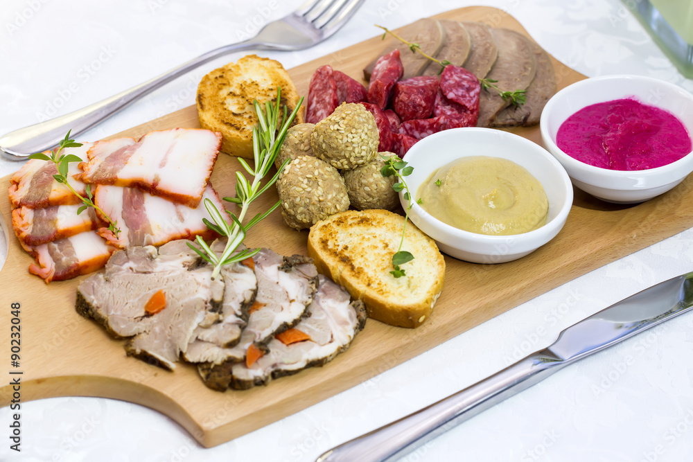 wooden dish with bacon and sausage on a white background