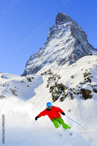 Skiing, Skier, Freeski, Freeride in Zermatt - man skiing downhill in fresh powder snow photo