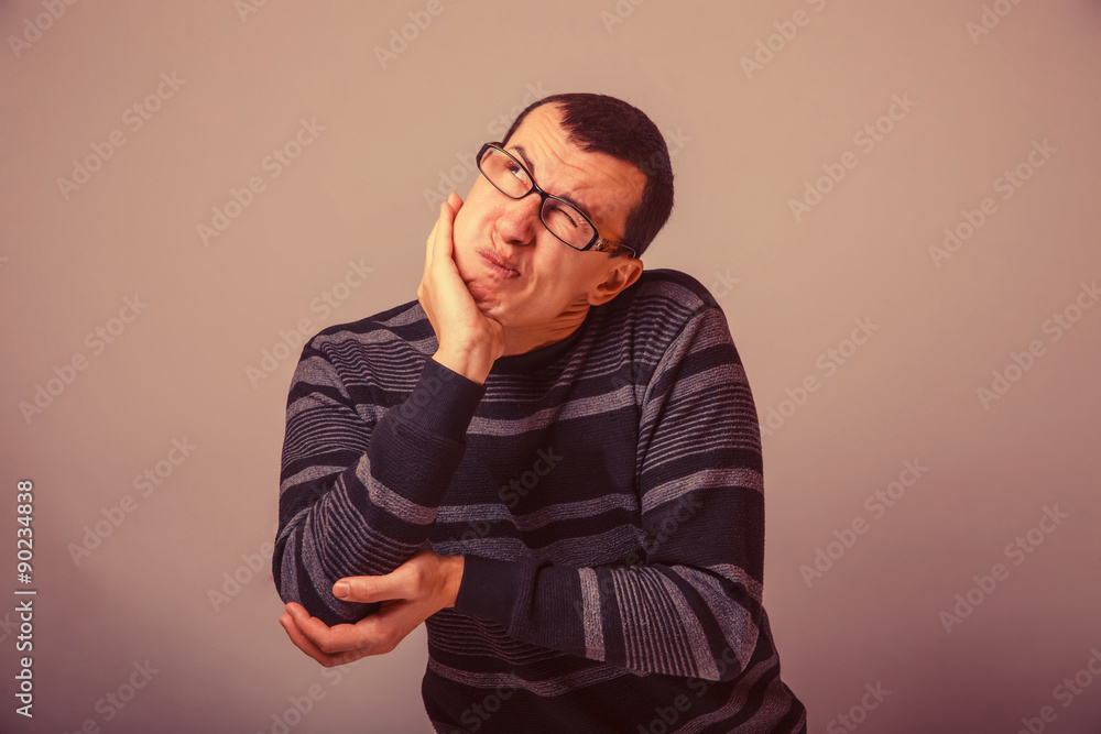 male of European appearance brunet pressed a hand to his cheek a male of European appearance brunet pressed a hand to his cheek a