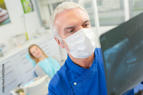 Senior dentist holding up an x-ray