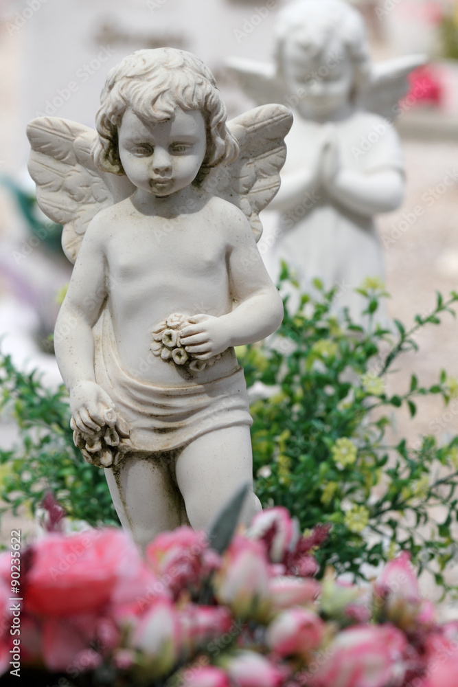 angel with floral wreath in hands on churchyard angel with floral wreath in hands on churchyard