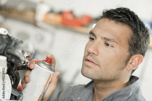 Mechanic using lubrication spray