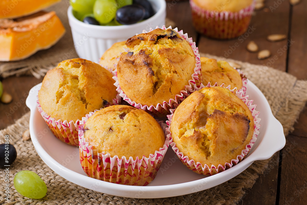 Appetizing and ruddy muffins with pumpkin and grapes Appetizing and ruddy muffins with pumpkin and grapes