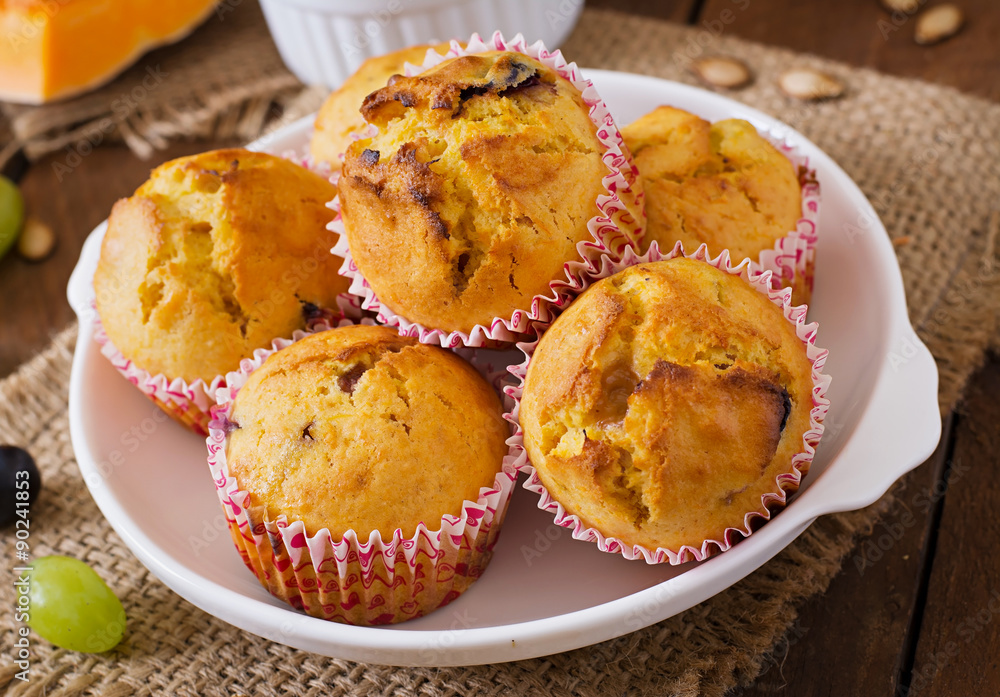 Appetizing and ruddy muffins with pumpkin and grapes Appetizing and ruddy muffins with pumpkin and grapes