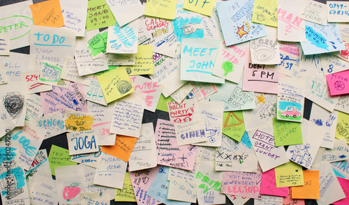 Fotografia Post-it notes sticked chaotically on the wall - busy concept