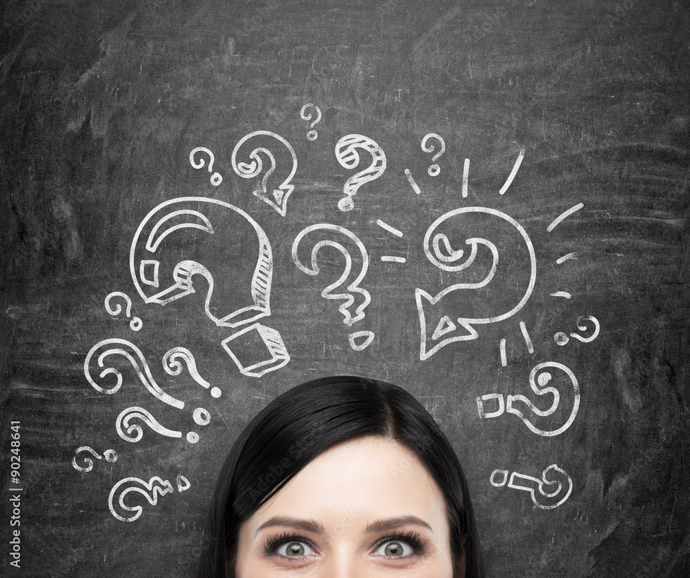 A forehead of the brunette girl who is pondering about unsolved problems. Question marks are drawn around the head. black chalkboard background. A forehead of the brunette girl who is pondering about unsolved problems. Question marks are drawn around the head. black chalkboard background.