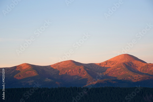 View of rosy mountain peaks of Chornogora range in Carpathians at the sunrise with Horverla the highest mountain of Ukraine