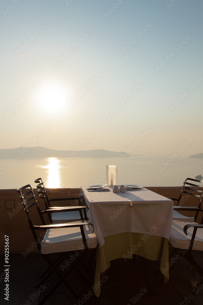 A sunset with the sea and a table is set for dinner