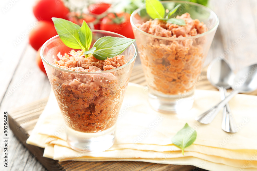 Glass with granita from fresh tomatoes on grey wooden background Glass with granita from fresh tomatoes on grey wooden background