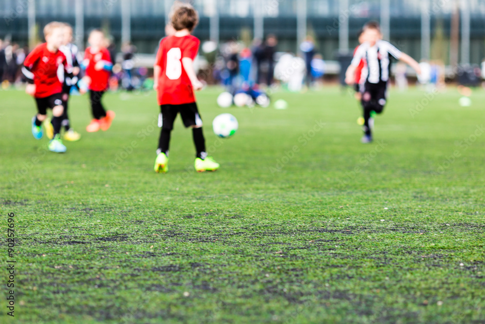 Fototapeta premium Blurred young kids playing soccer