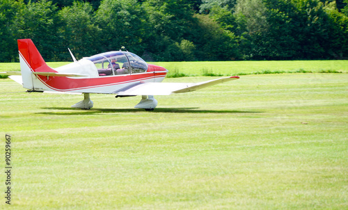 red sports plane on a meadow