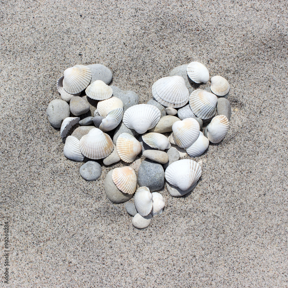 Heart / Heart made of shells and pebbles in the sand
