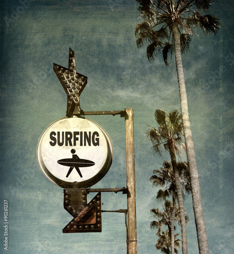 aged and worn vintage photo of surfing sign on beach