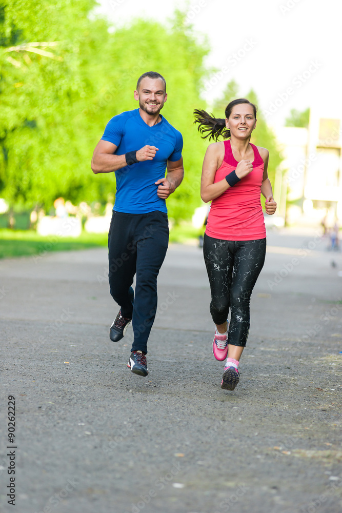 Fototapeta premium Runners training outdoors working out. City running couple