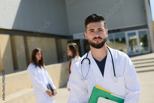 portrait of a handsome young man medical student outdoor in front of hospital university campus