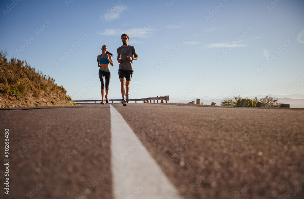 Obraz premium Two young people running on country road