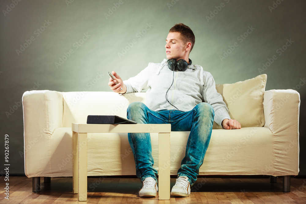man on couch with headphones smartphone and tablet man on couch with headphones smartphone and tablet