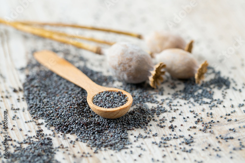 Photography poppy seeds in a wooden spoon on wooden surface