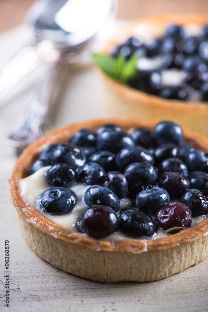 Homemade blueberry tart on white wood Homemade blueberry tart on white wood