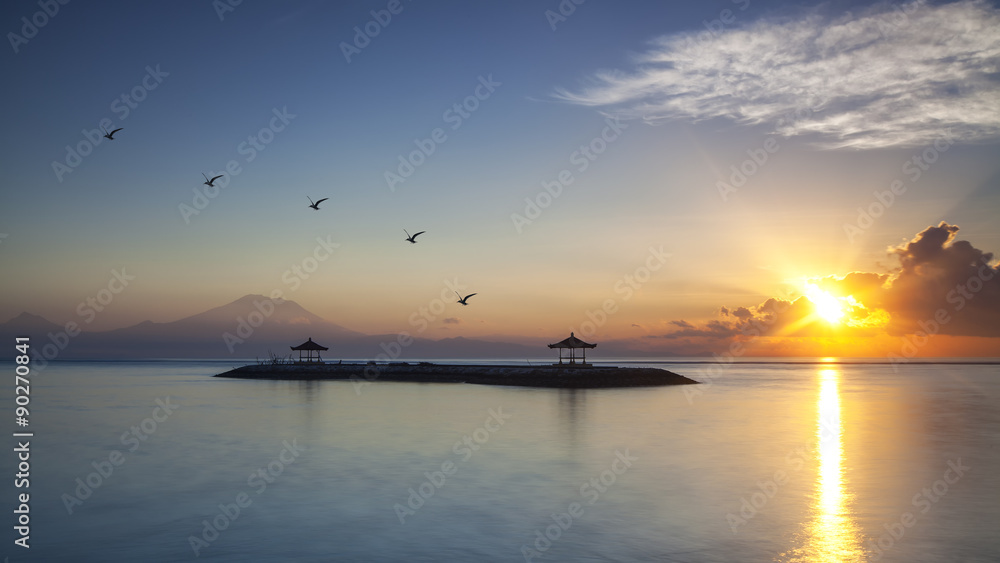 Harmony of life. The morning Sun rays warmth up the air of Sanur Beach and Mount Agung in Bali, Indonesia.