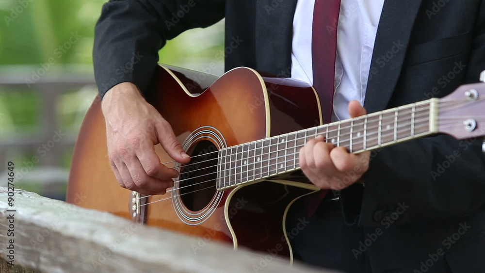 acoustic guitar which man in suit and tie plays acoustic guitar which man in suit and tie plays