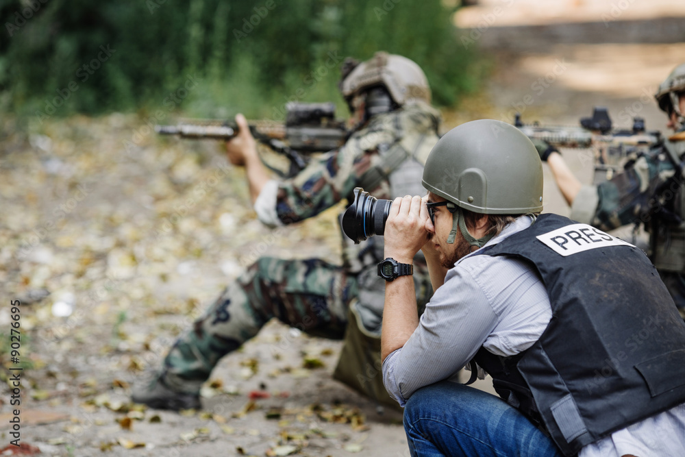 Fototapeta premium Photojournalist documenting war conflict