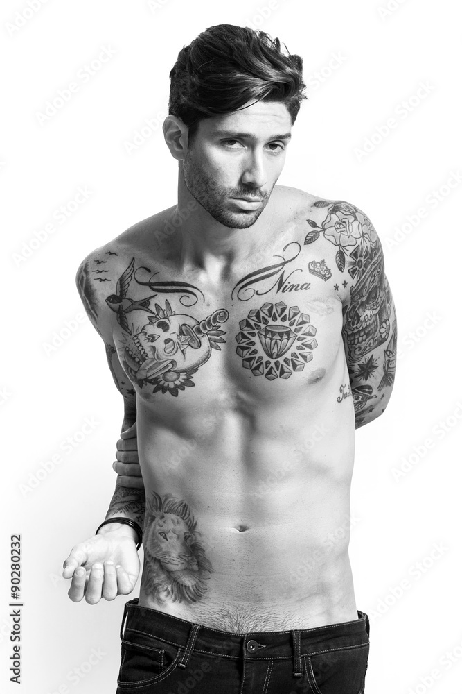 Fototapeta premium Sexy tattooed man portrait looking at camera black and white