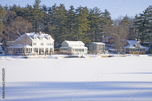 Obraz na plátně Houses on frozen pond with snow, Stow, Ma., New England, USA