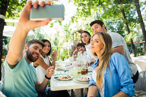 Friends making selfie photo in outdoor restaurant