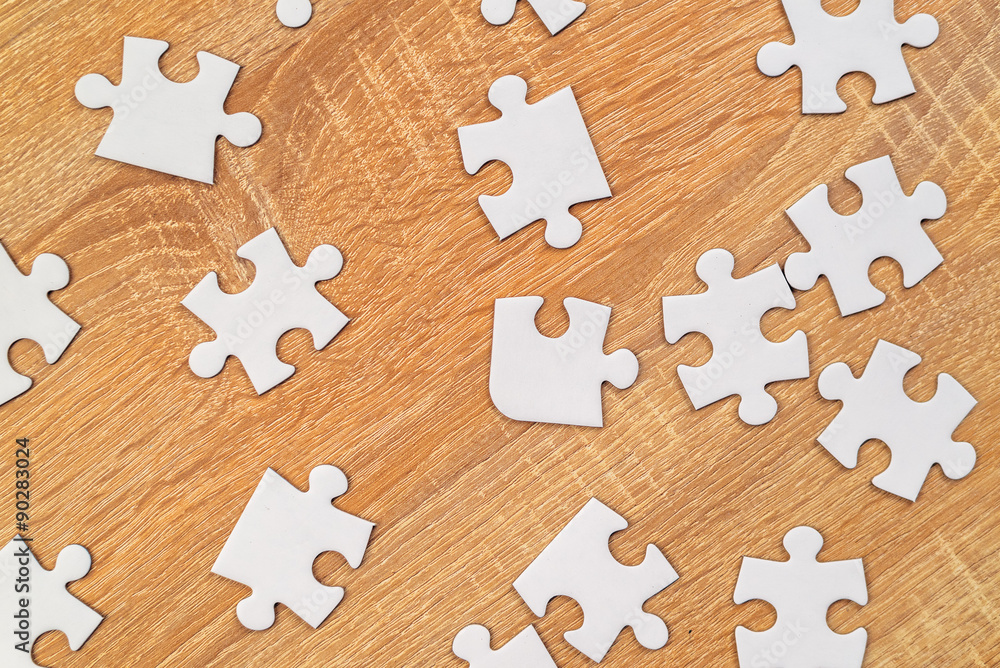 White jigsaw puzzle pieces scattered on wooden table Stock-Foto | Adobe  Stock