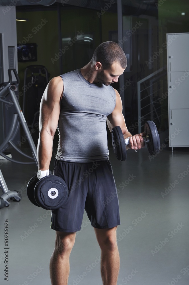 Handsome Muscular Male Model in a Standing Position With Dumbbel Handsome Muscular Male Model in a Standing Position With Dumbbel