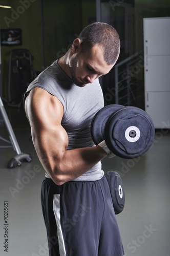 Handsome Muscular Male Model Doing Biceps Exercise with Dumbbell
