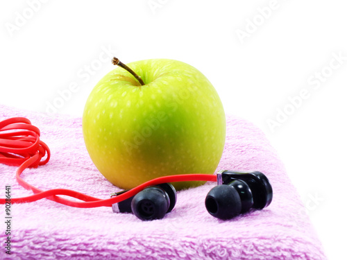 green apple fitness towel and headphones on white background