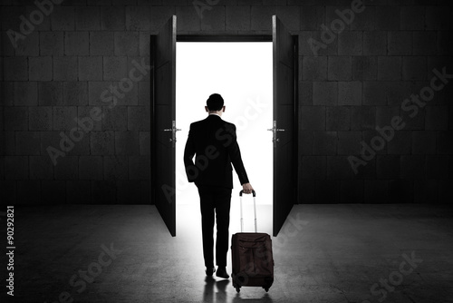 Back view of business man standing toward door