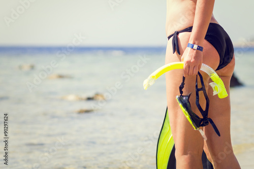 Young woman holding snorkeling gear looking at the sea © skumer