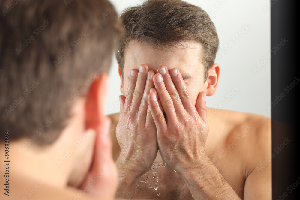 Fototapeta premium Man washing his face with clean water