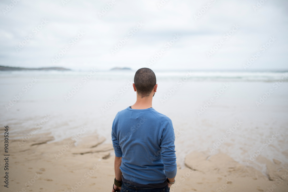 Man in the beach looking to the sea Man in the beach looking to the sea