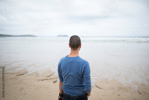Man in the beach looking to the sea