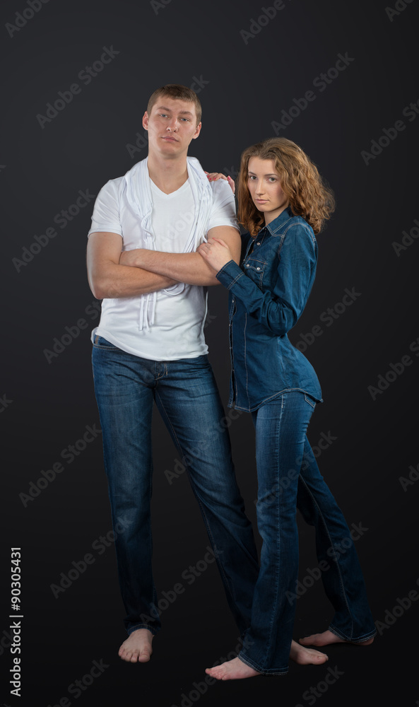 Full length portrait of young couple on dark background Full length portrait of young couple on dark background