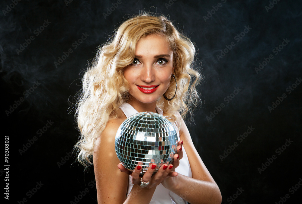 Naklejka premium Beautiful young woman holding disco ball at night club