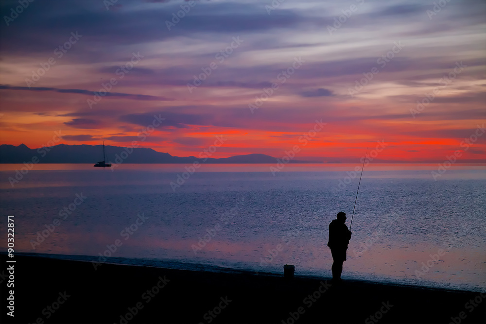 Amazing sunrise with a silhouette of fisherman
